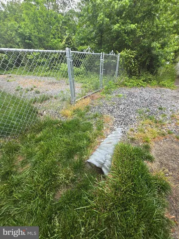 a view of a yard with a wooden fence