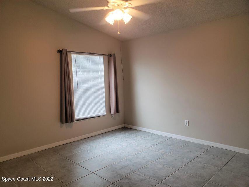5649 Beaverbrook Street Cocoa, FL 32927 - Photo 15 of 29 an empty room with a chandelier fan and windows