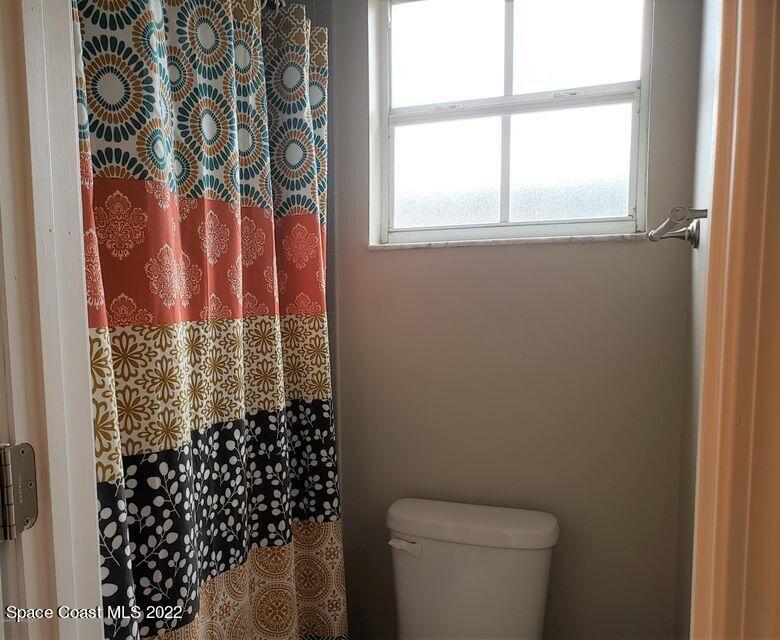5649 Beaverbrook Street Cocoa, FL 32927 - Photo 18 of 29 a bathroom with a toilet and a shower curtain
