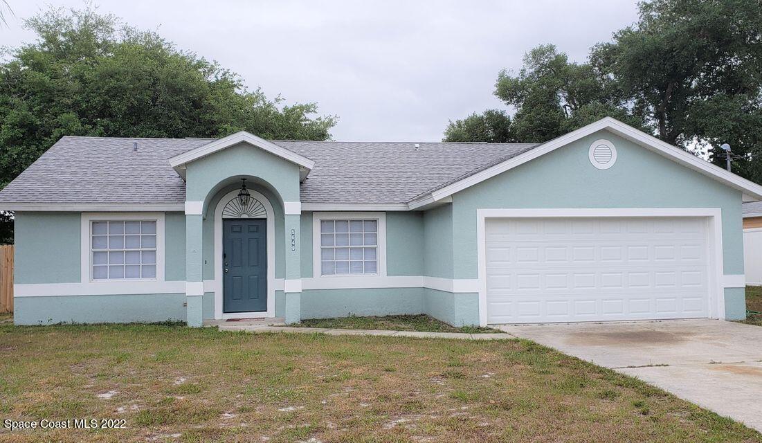 5649 Beaverbrook Street Cocoa, FL 32927 - Photo 2 of 29 a front view of a house with a garden and garage
