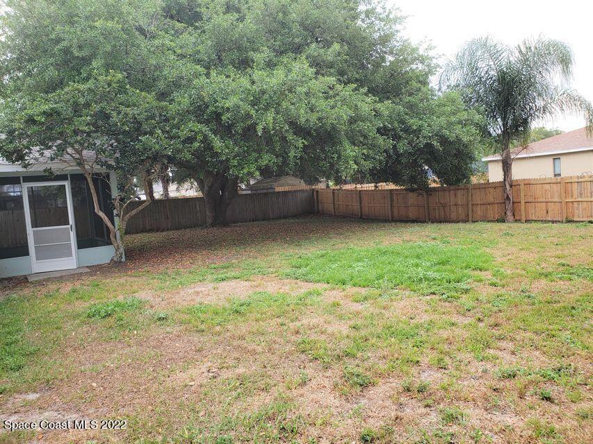 5649 Beaverbrook Street Cocoa, FL 32927 - Photo 21 of 29 a view of a backyard with large trees and plants