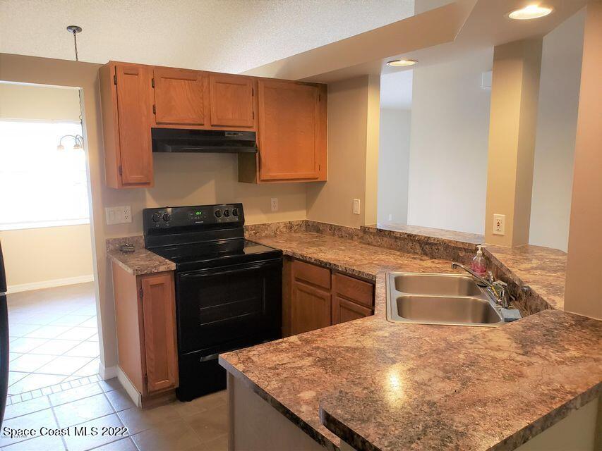 5649 Beaverbrook Street Cocoa, FL 32927 - Photo 8 of 29 a kitchen with a sink stove and refrigerator