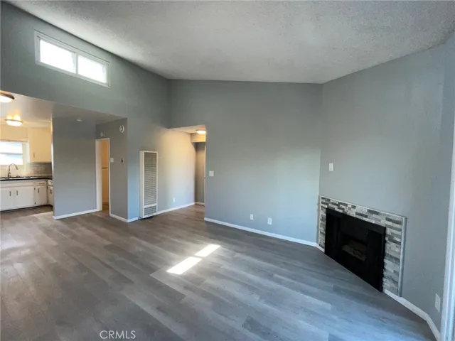 an empty room with wooden floor and fireplace
