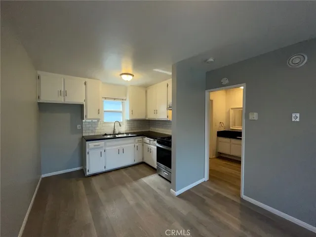 a kitchen with granite countertop a stove top oven and sink