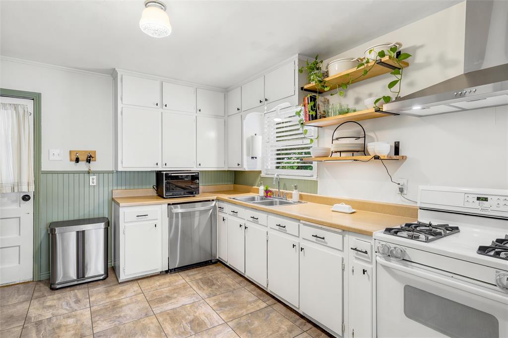 3012 Mitchell Avenue Waco, TX 76708 - Photo 6 of 18 Kitchen featuring white cabinetry, light wood-finish countertops, stainless steel dishwasher, and a white gas range