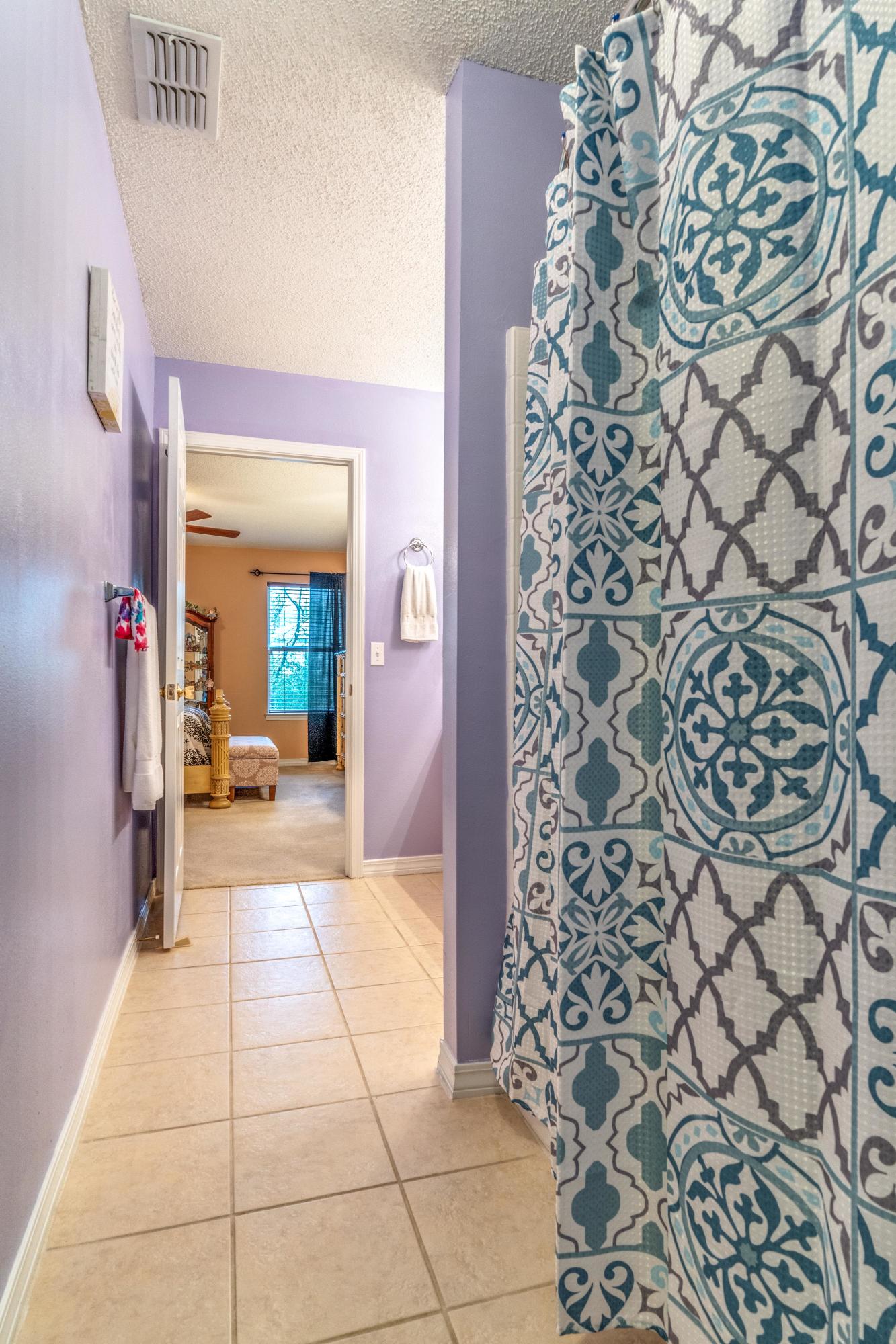 272 Limestone Circle Crestview, FL 32539 - Photo 20 of 30 a hallway with a black white checkered floor and a bathroom view