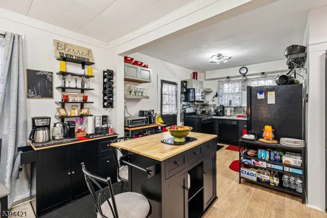 a room with stainless steel appliances lots of furniture and clutter