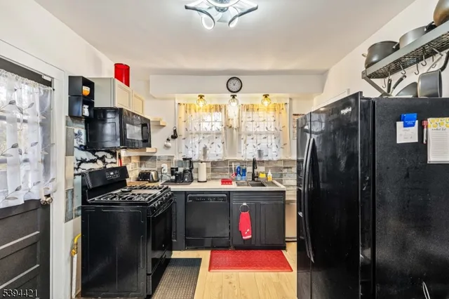 a kitchen with stainless steel appliances granite countertop a refrigerator a stove and a sink
