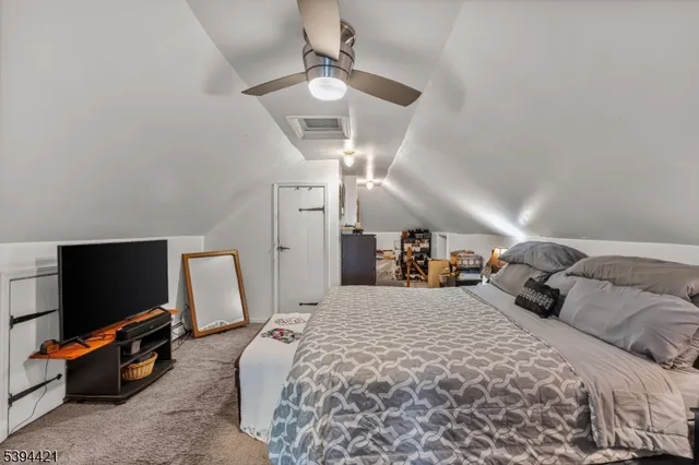 a bed room with a bed a television and a chair