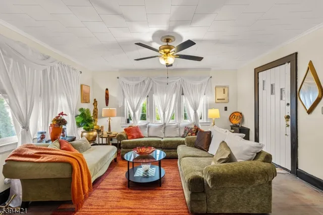 a living room with furniture ceiling fan and a window