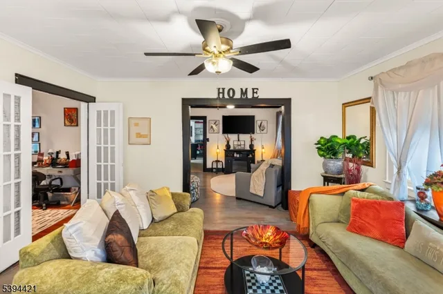a living room with furniture a ceiling fan and a window