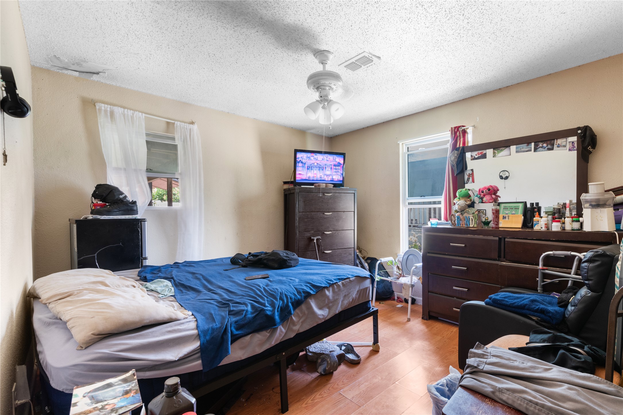 7105 Bethune Avenue Austin, TX 78752 - Photo 7 of 13 Bedroom with wood finished floors and a textured ceiling