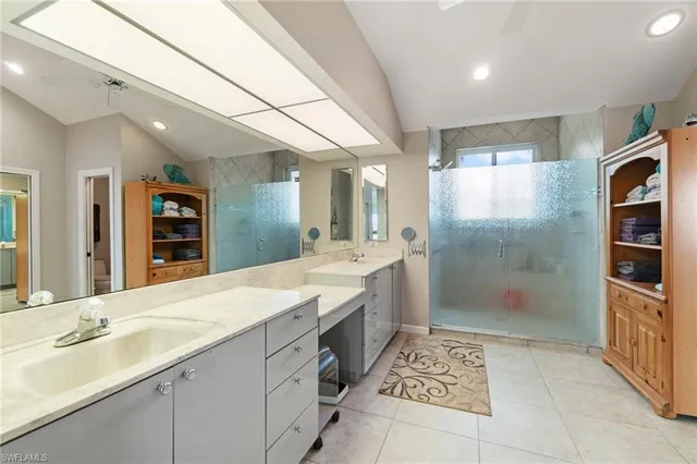 a large bathroom with a glass door shower and sink