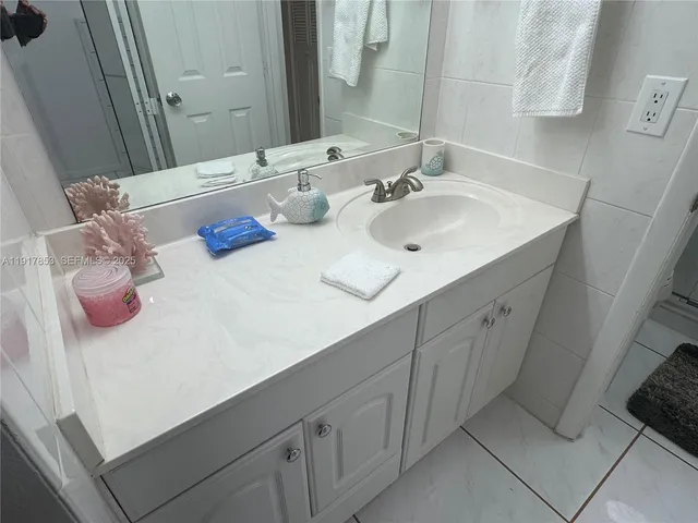 a bathroom with a granite countertop sink a toilet and shower