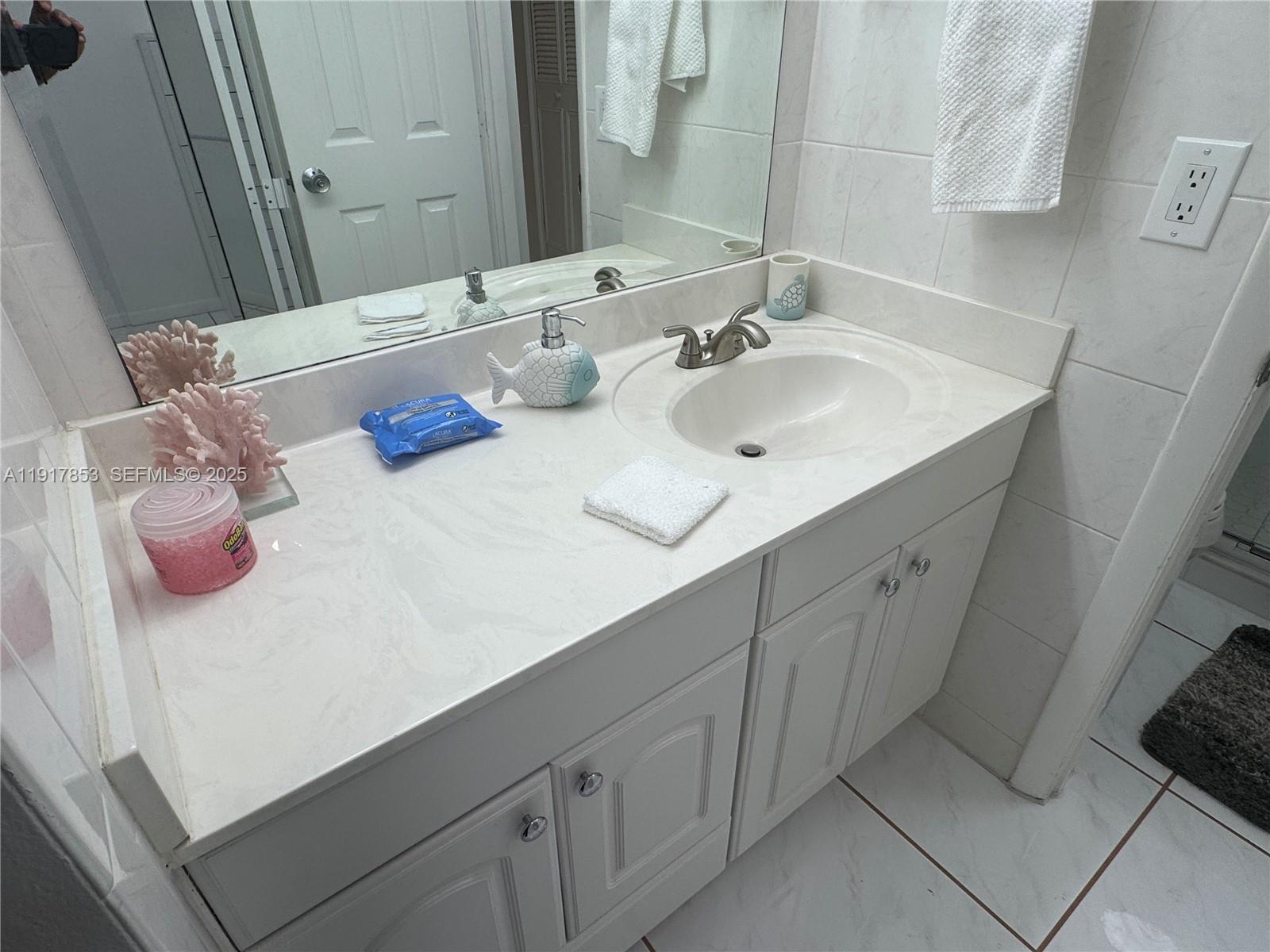 6050 Northwest 64th Avenue, Unit 306 Tamarac, FL 33319 - Photo 16 of 31 a bathroom with a sink and a mirror