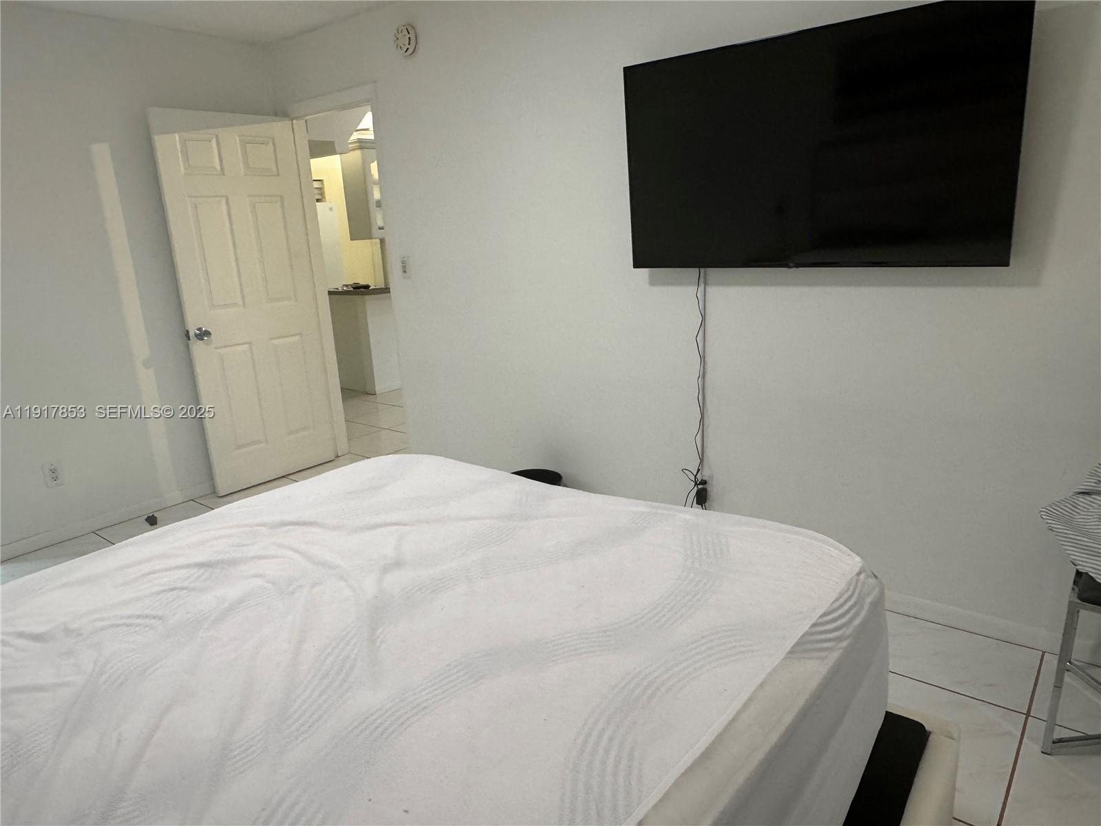 6050 Northwest 64th Avenue, Unit 306 Tamarac, FL 33319 - Photo 19 of 31 a bedroom with a bed and a flat screen tv