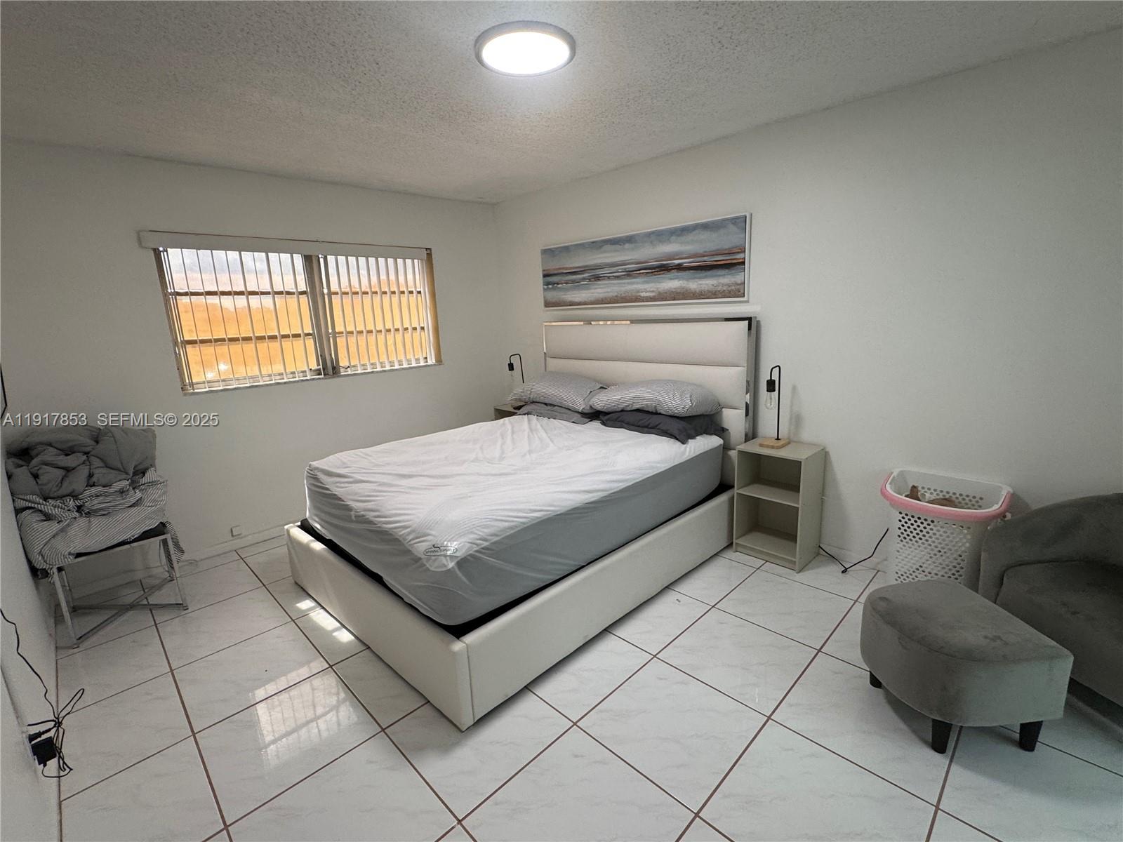 6050 Northwest 64th Avenue, Unit 306 Tamarac, FL 33319 - Photo 20 of 31 a bedroom with a bed and a chair