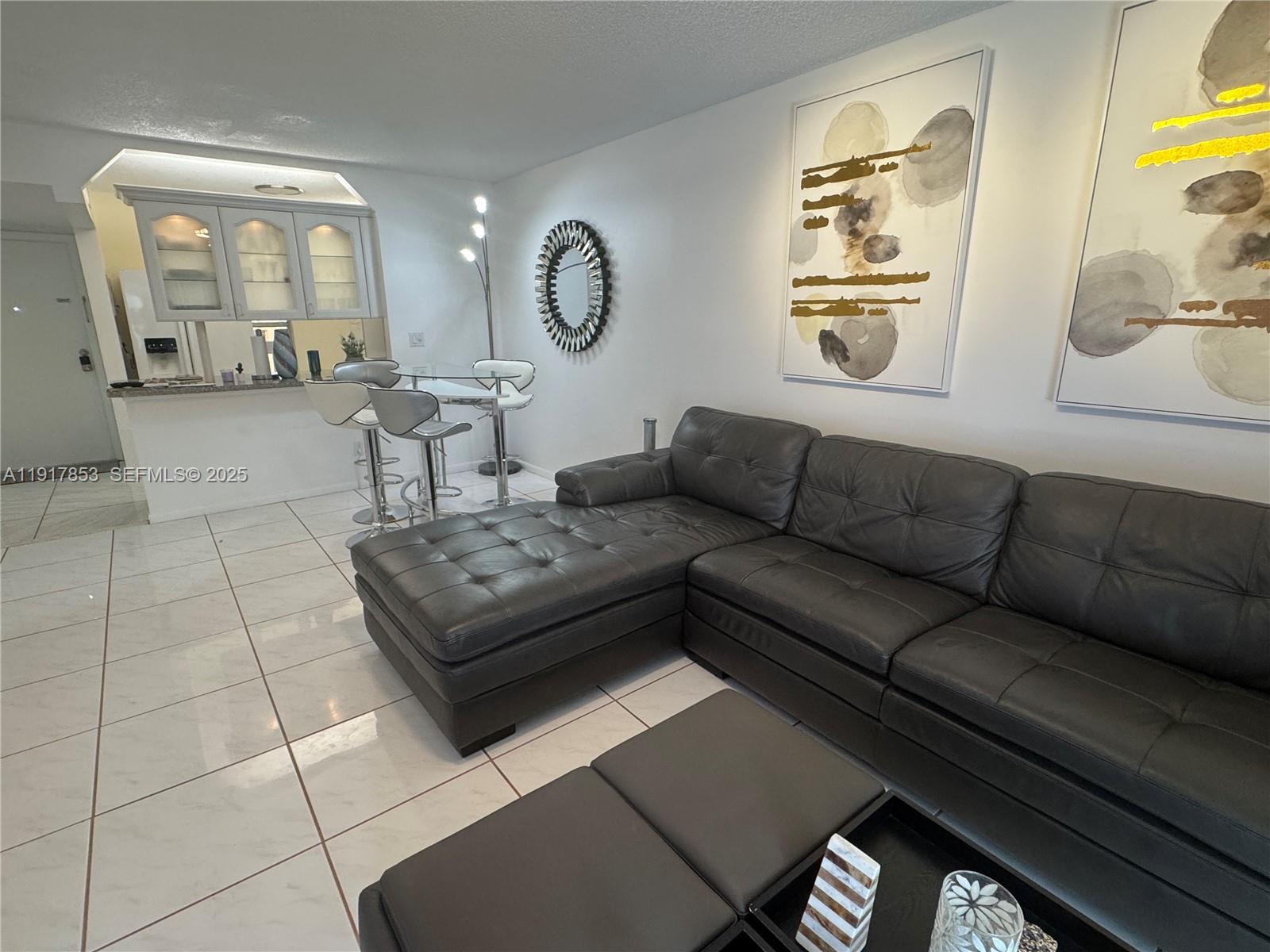 6050 Northwest 64th Avenue, Unit 306 Tamarac, FL 33319 - Photo 23 of 31 a living room with furniture and a mirror