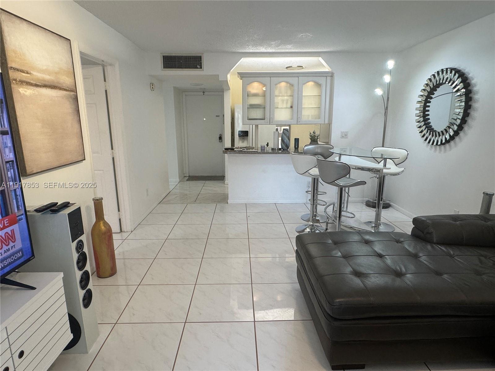 6050 Northwest 64th Avenue, Unit 306 Tamarac, FL 33319 - Photo 24 of 31 a living room with furniture and a mirror