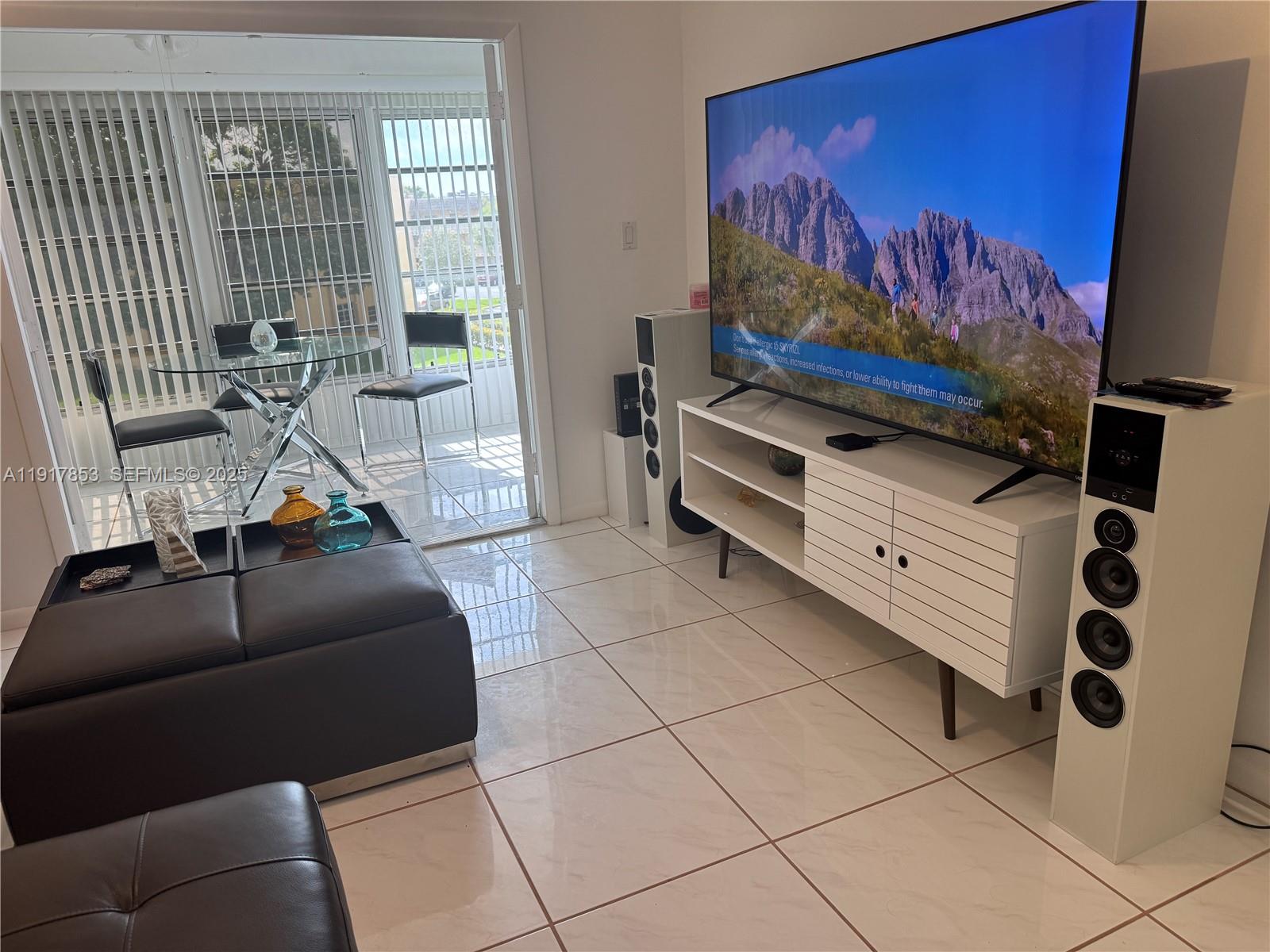 6050 Northwest 64th Avenue, Unit 306 Tamarac, FL 33319 - Photo 3 of 31 a living room with furniture and a flat screen tv