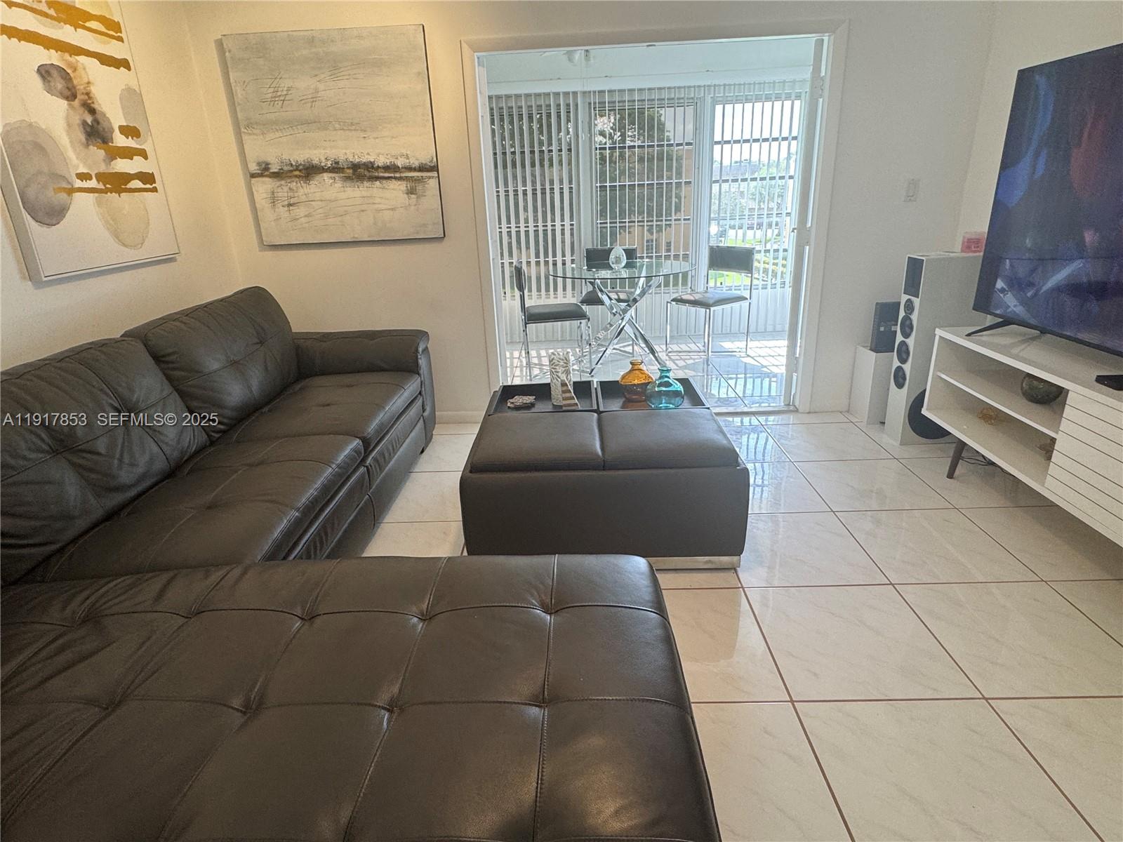 6050 Northwest 64th Avenue, Unit 306 Tamarac, FL 33319 - Photo 4 of 31 a living room with furniture and a flat screen tv