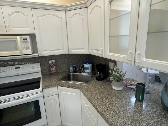 a kitchen with a stove a microwave and cabinets