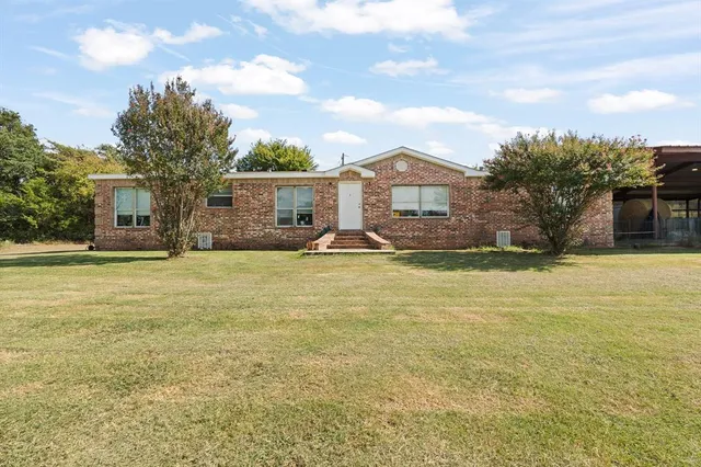 a front view of house with yard and trees