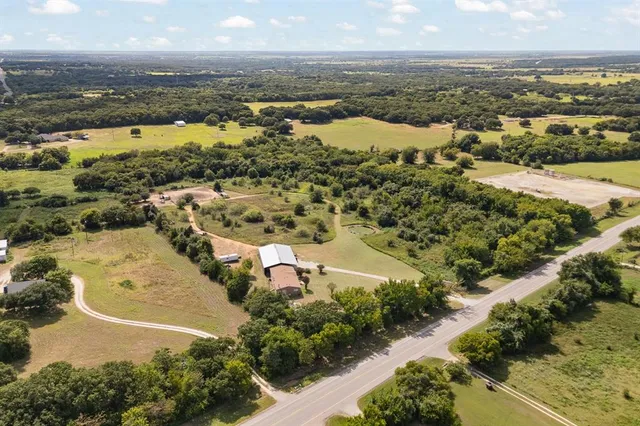 an aerial view of ocean and residential houses with outdoor space