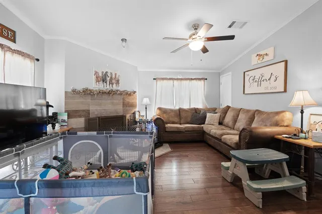 a living room with furniture a flat screen tv and a fireplace