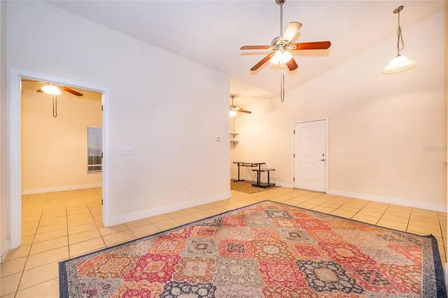 a view of an empty room with window and a kitchen
