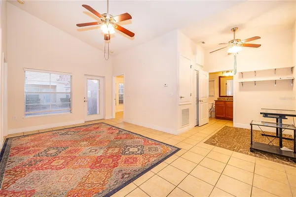 a view of an empty room with a fireplace and a chandelier fan