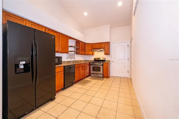a kitchen with stainless steel appliances granite countertop a stove a sink and a refrigerator