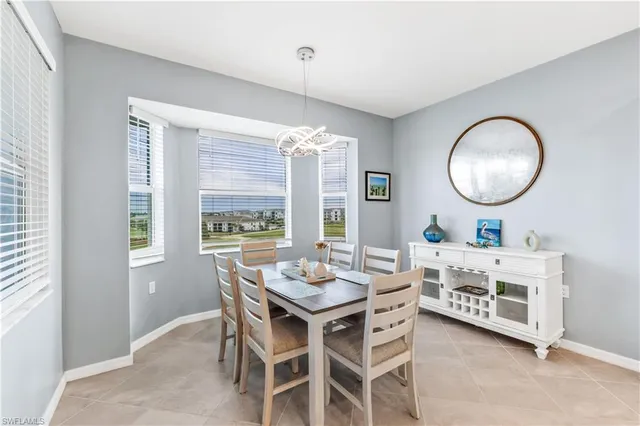 a dining room with furniture a large window and wooden floor