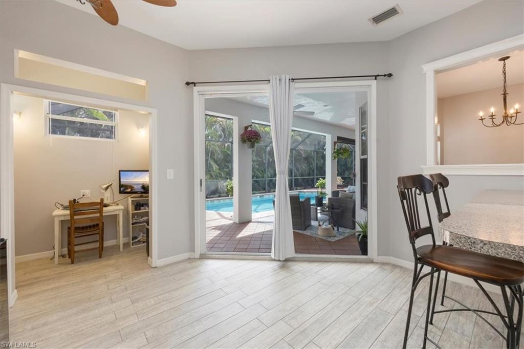 496 Raven Way Naples, FL 34110 - Photo 12 of 31 a dining room with wooden floor and windows