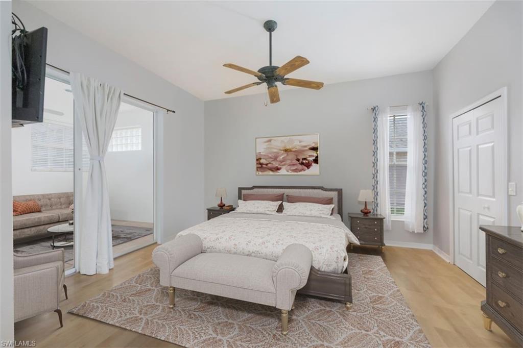 496 Raven Way Naples, FL 34110 - Photo 15 of 31 a bedroom with a bed and a chandelier