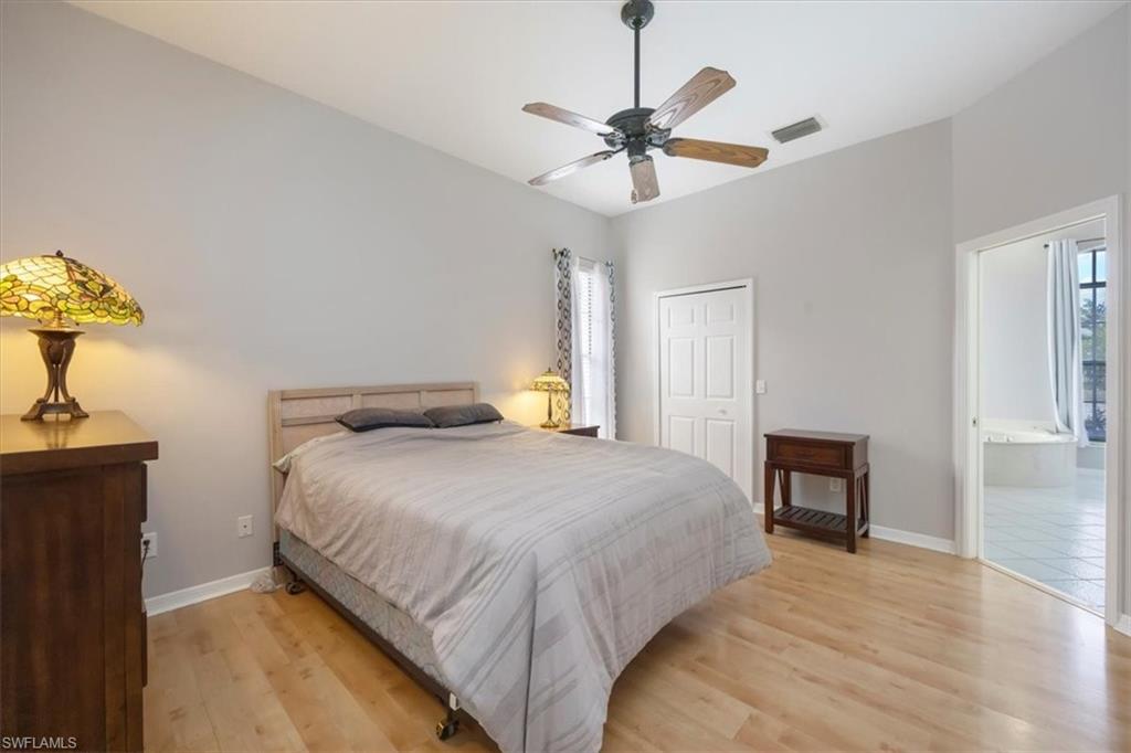 496 Raven Way Naples, FL 34110 - Photo 17 of 31 a bedroom with a bed and a chandelier