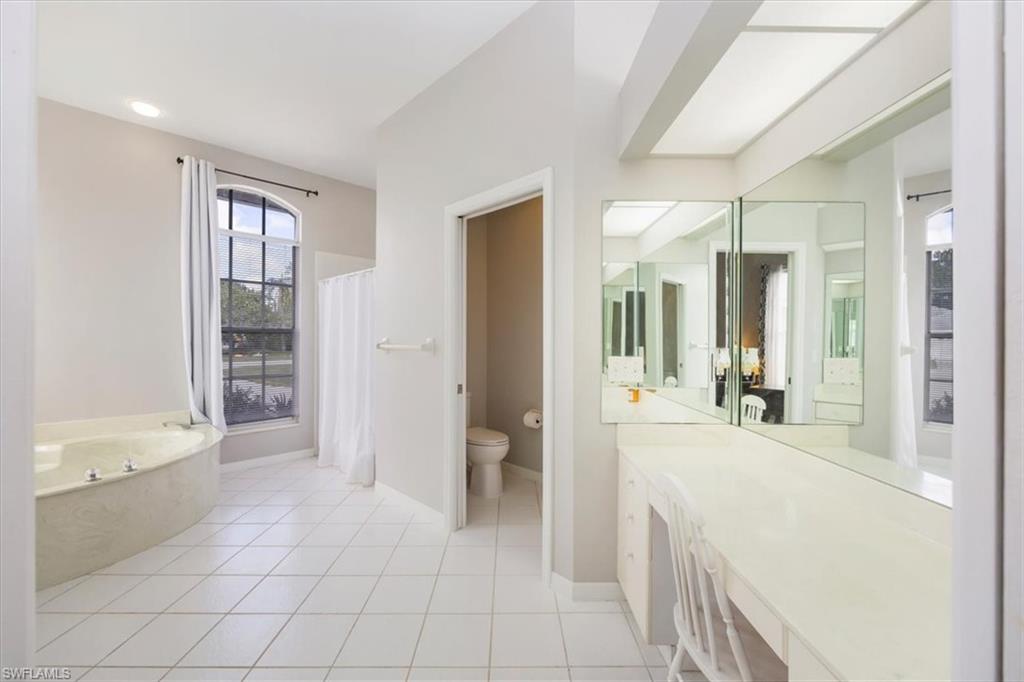 496 Raven Way Naples, FL 34110 - Photo 19 of 31 a bathroom with a tub shower and sink