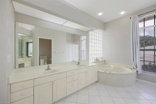 a bathroom with a tub sink shower and mirror