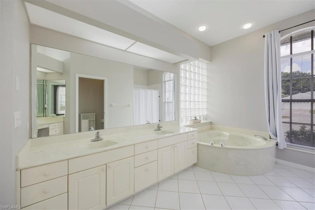 496 Raven Way Naples, FL 34110 - Photo 20 of 31 a bathroom with a tub sink shower and mirror