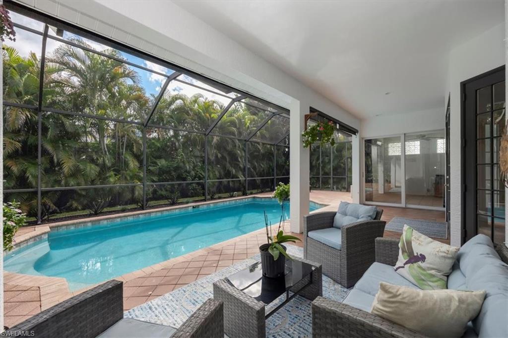 496 Raven Way Naples, FL 34110 - Photo 28 of 31 a living room with patio yard furniture and garden view