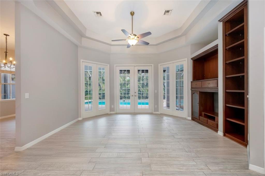 496 Raven Way Naples, FL 34110 - Photo 5 of 31 a view of an empty room with a fireplace and a window