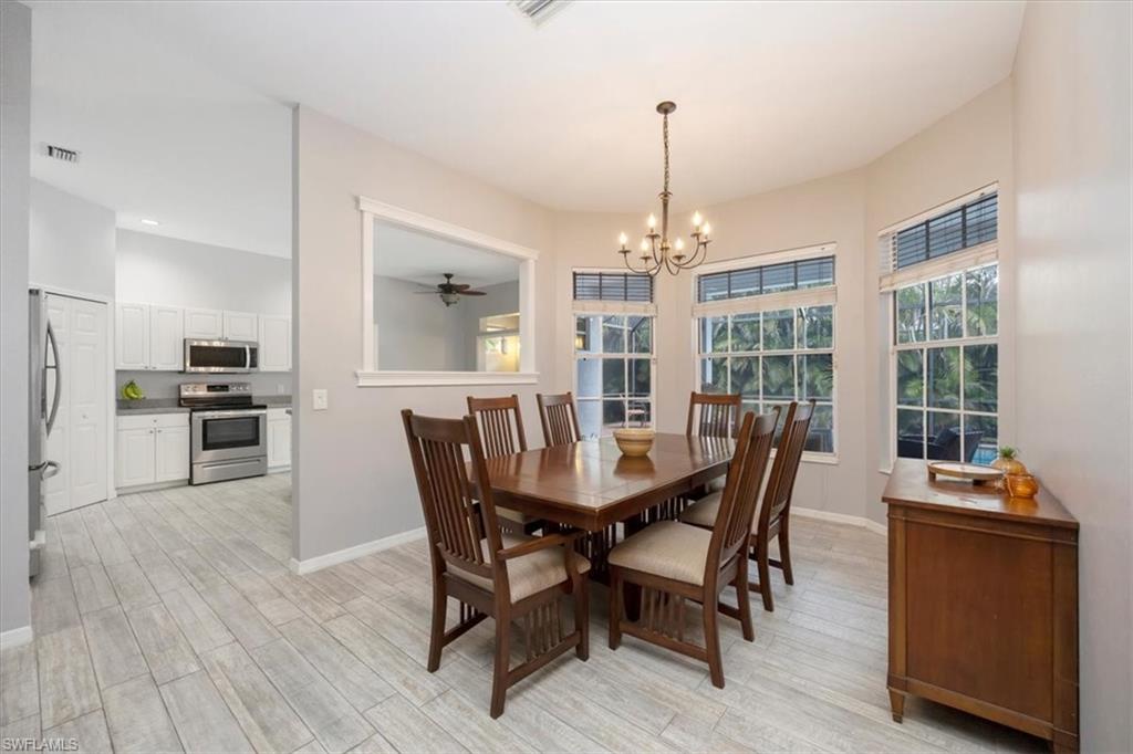 496 Raven Way Naples, FL 34110 - Photo 7 of 31 a view of a dining room with furniture window and wooden floor