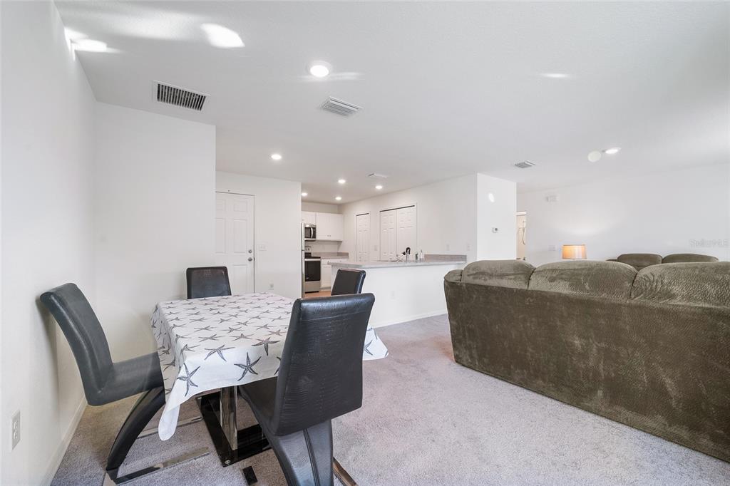 4400 Southwest 155th Street Ocala, FL 34473 - Photo 28 of 41 a living room with furniture and a dining table with kitchen view