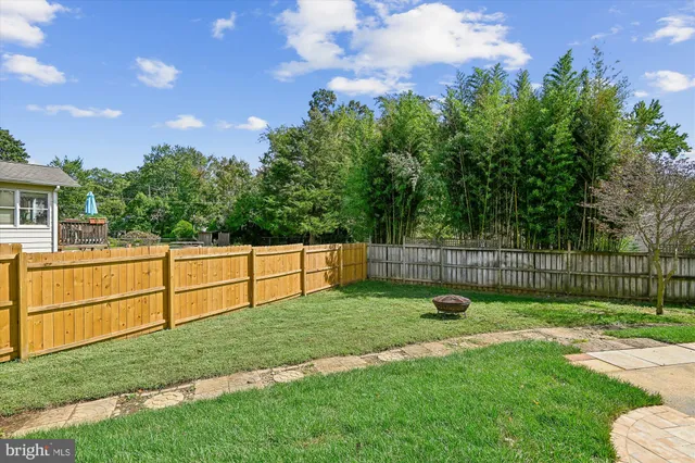 a view of a backyard with a garden and wooden fence