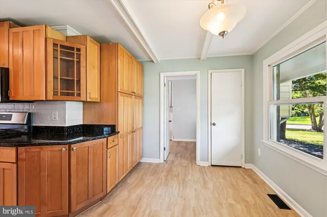 a kitchen that has a lot of cabinets and wooden floor