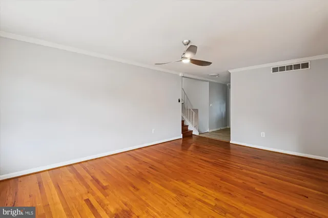a view of an empty room with wooden floor