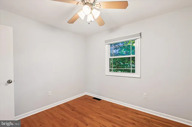 an empty room with a window and wooden floor