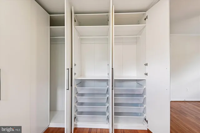 a view of walk in closet with empty racks