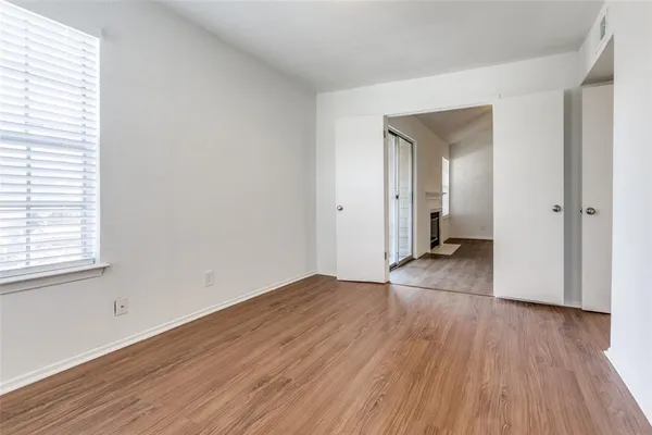 an empty room with wooden floor and a window