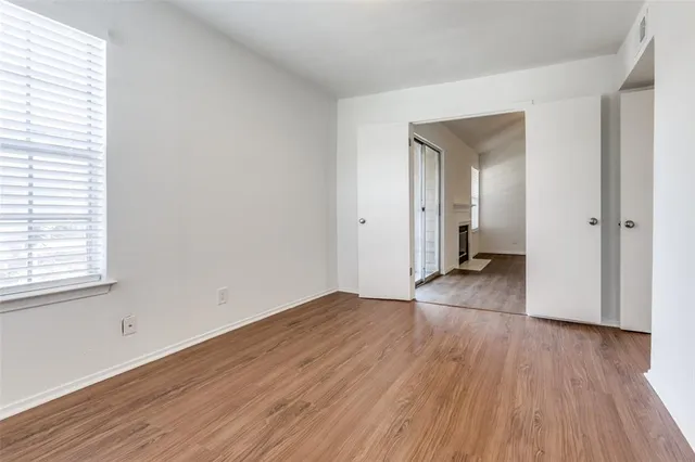 an empty room with wooden floor and a window